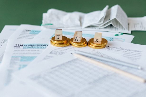 Close de formulários financeiros, recibos e moedas sobre uma superfície, representando contabilidade e pagamentos.