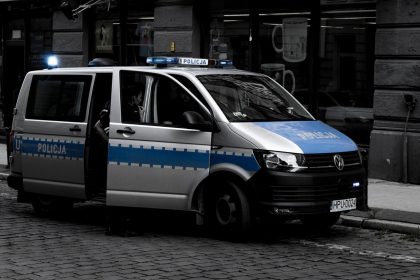 Van policial estacionada em uma rua urbana de paralelepípedos.