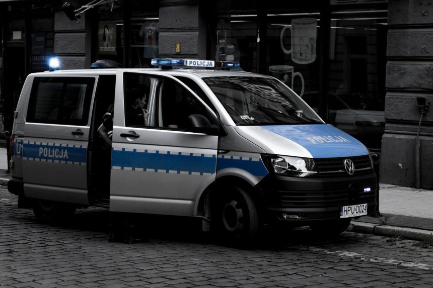 Van policial estacionada em uma rua urbana de paralelepípedos.