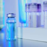 Frascos e tubos de ensaio com líquido azul em um laboratório iluminado por luz fluorescente