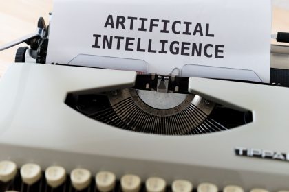 Máquina de escrever com as palavras “ARTIFICIAL INTELLIGENCE” em uma folha de papel.